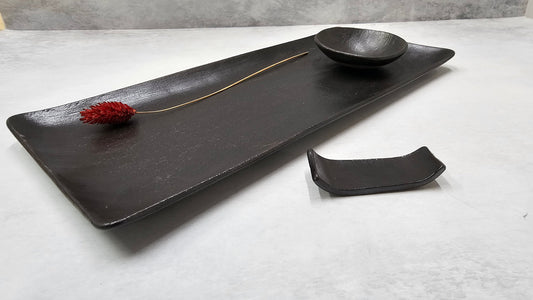 מגש שחור עם קערית ומעמד מקלות