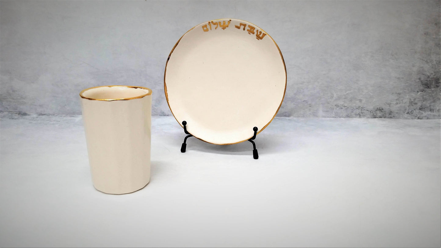 כוס קידוש ותחתית בלבן וזהב עם כיתוב שבת שלום