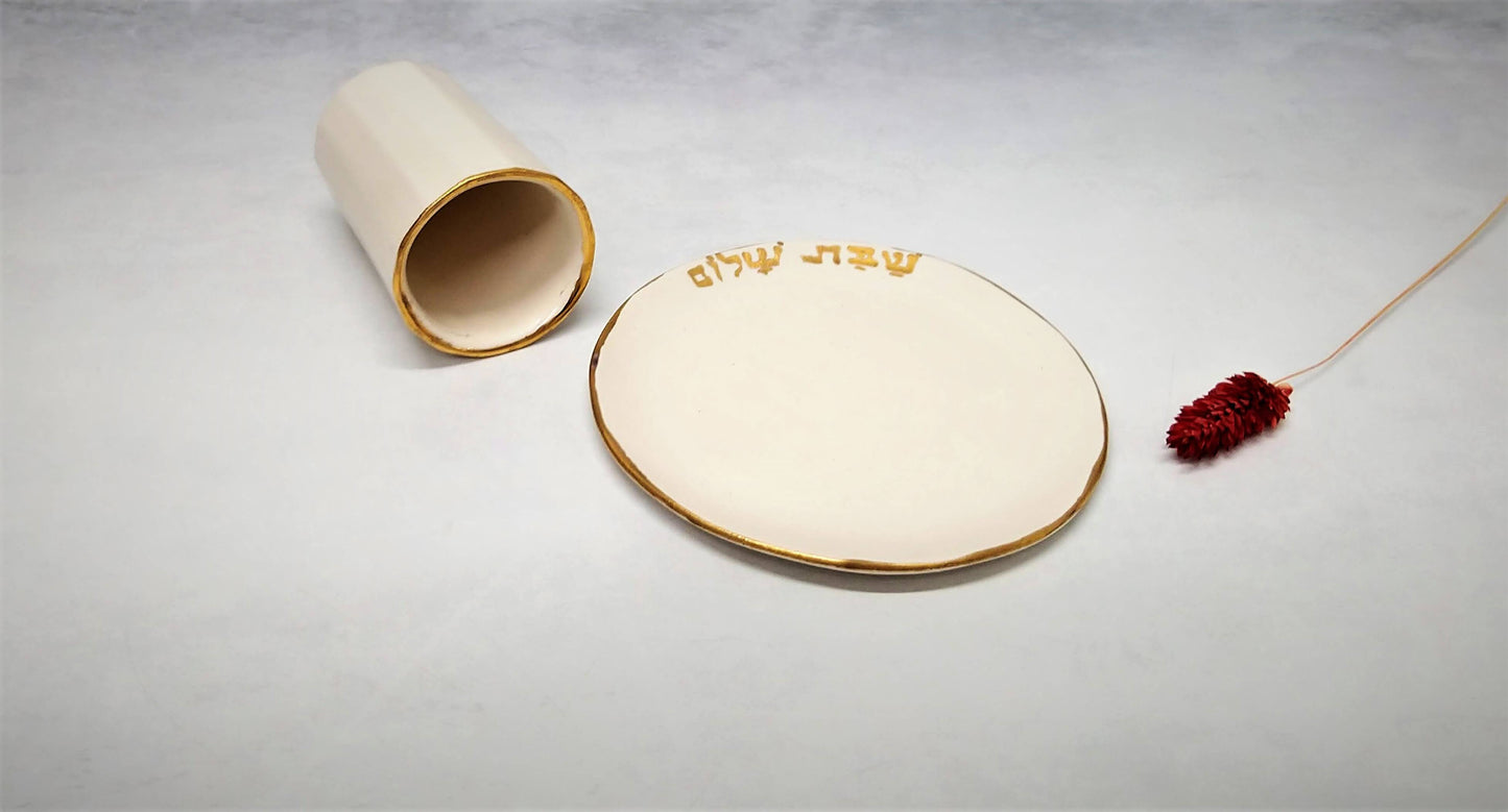 כוס קרמיקה עם תחתית עליה כיתוב בזהב של שבת שלום