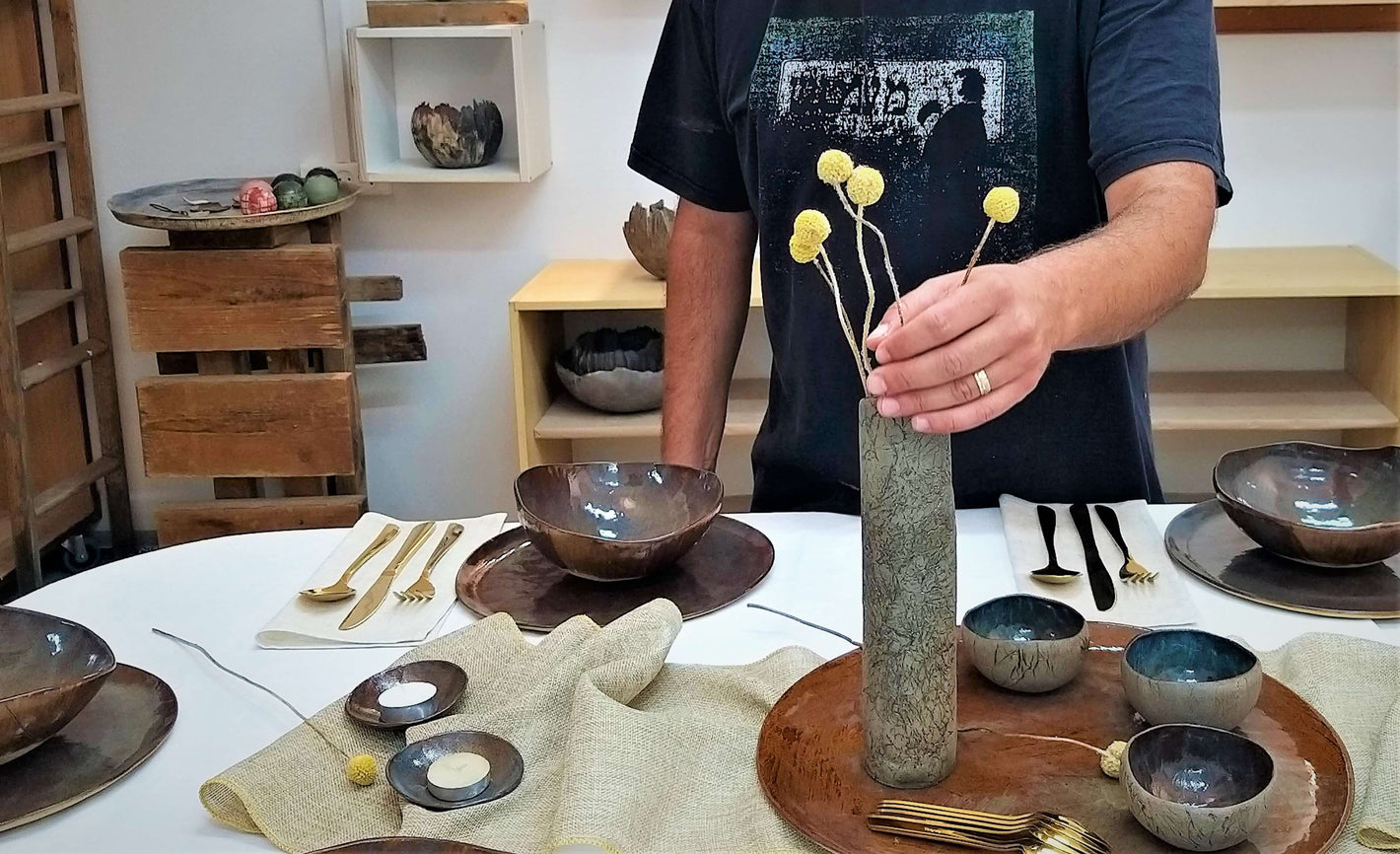 סט קרמיקה מונח על שולחן כולל שלוש צלחות קערות וקעריות